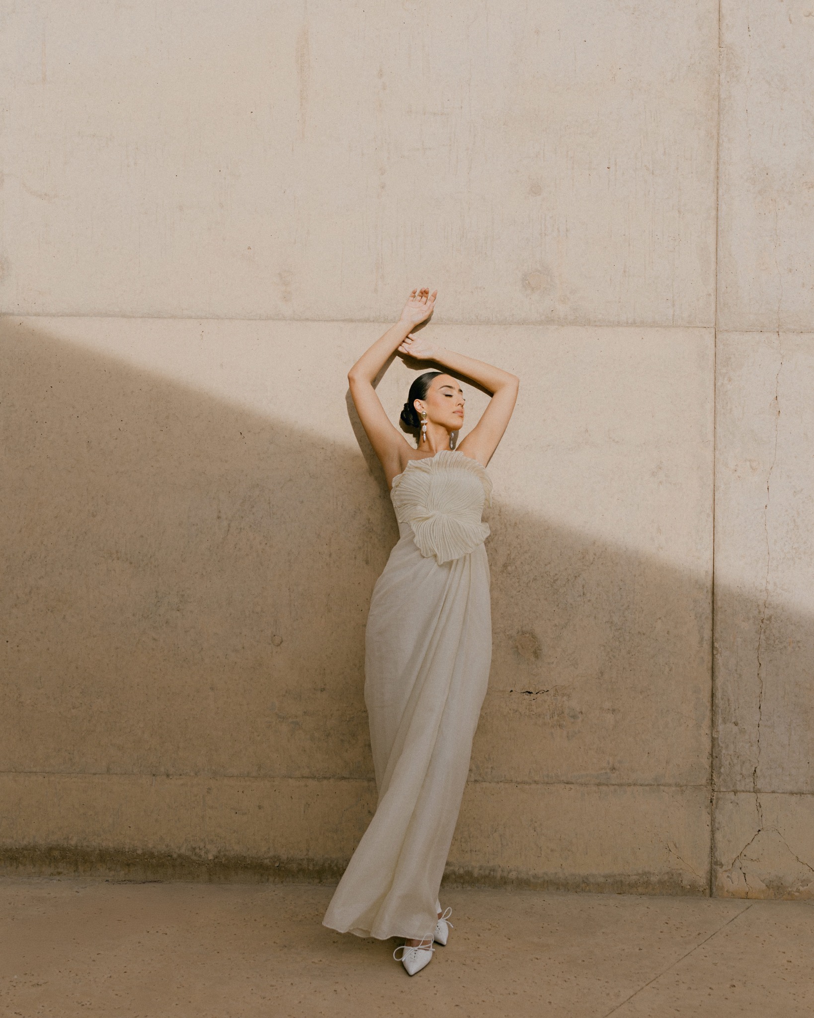 Bridal fashion portrait against a warm stone wall