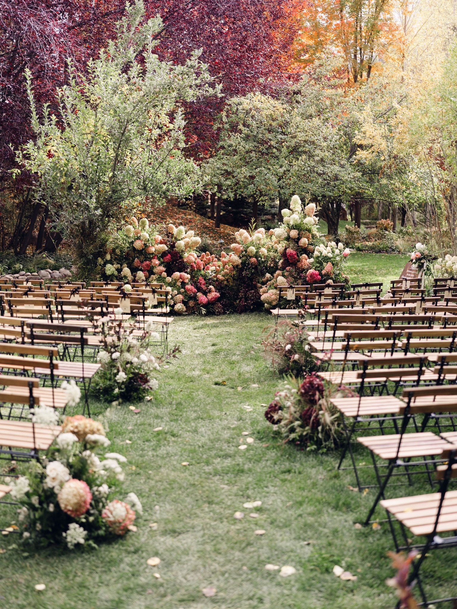 Garden wedding ceremony set with flowers and rows of chairs