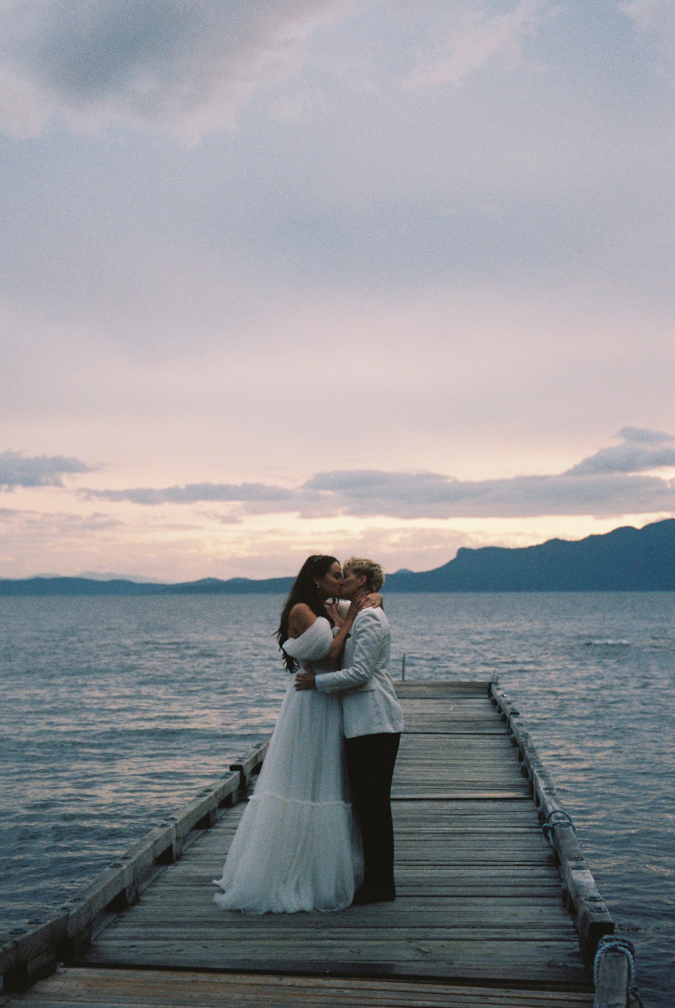 Newlyweds together at dusk beside a lake